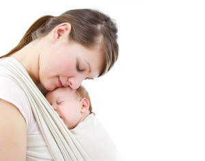 young mother carrying a  newborn sleepimg  baby